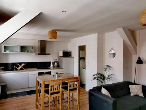 un salon avec une table et une cuisine dans l'établissement Le Boho du centre ville, à Lens