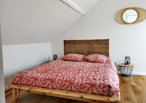 une chambre avec un lit avec une couette rouge et un miroir dans l'établissement Le Boho du centre ville, à Lens