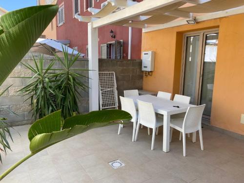 Una mesa blanca y sillas en un patio. en Casa Vacanze Calabro', en SantʼAntìoco