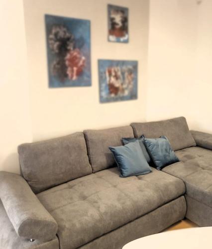 a brown couch in a living room with two blue pillows at Three Diamonds Residence in Dunajská Streda