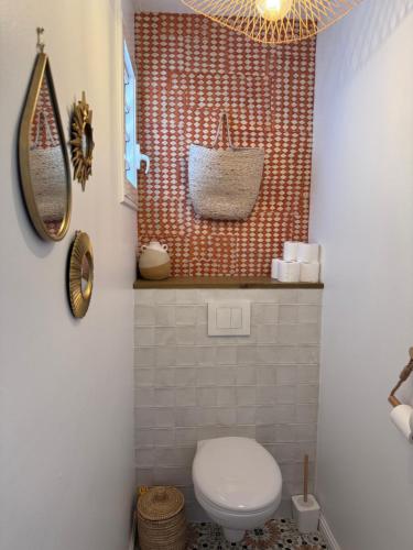 a bathroom with a toilet and a mirror at Villa Ô in Les Avirons