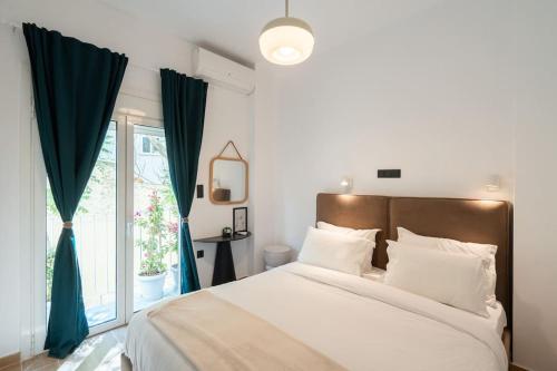 a bedroom with a bed with blue curtains and a window at 1BR Stylish Apt 20 Minutes from Acropolis in Athens