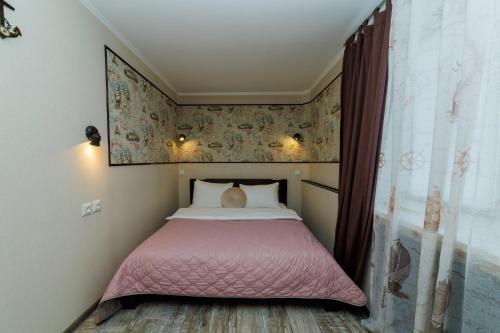 a small bedroom with a bed with a pink blanket at Морська квартира у центрі м Полтава Мережа AlexApartments Документи для відряджень Цілодобове безконтактне заселення 24-7 in Poltava