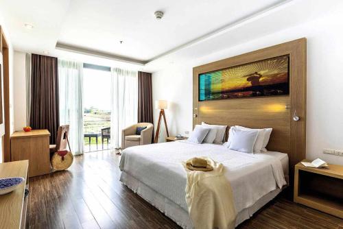 a hotel room with a bed and a large window at ROBINSON Nam Hoi An in Tam Ky