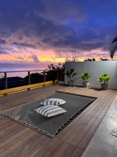 a sunset on the deck of a house at Villa Ô in Les Avirons