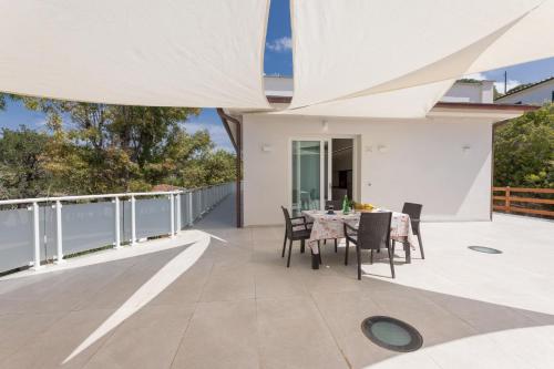 a patio with a table and chairs on a balcony at Camping Bungalow Lido in Capoliveri