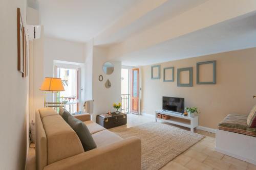 a living room with a couch and a tv at Il Porticciolo by Rent All Como in Carate Urio