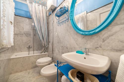 a bathroom with a sink and a toilet and a mirror at BIBI BOUTIQUE AREZZO Living Suite Rosafragola & Verdeconiglio in Arezzo