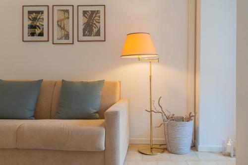 a living room with a couch and a lamp at Il Porticciolo by Rent All Como in Carate Urio