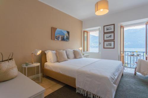 a bedroom with a large bed and a balcony at Il Porticciolo by Rent All Como in Carate Urio