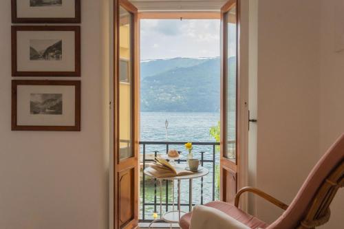 a room with a table and a view of the ocean at Il Porticciolo by Rent All Como in Carate Urio