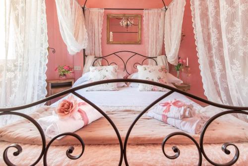a bedroom with a bed with pink walls and curtains at BIBI BOUTIQUE AREZZO Living Suite Rosafragola & Verdeconiglio in Arezzo