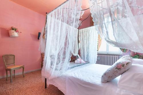 a bedroom with a canopy bed with white curtains at BIBI BOUTIQUE AREZZO Living Suite Rosafragola & Verdeconiglio in Arezzo