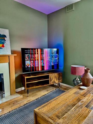 a living room with a large flat screen tv at Two bedroom maisonette in the heart of the West End in Glasgow