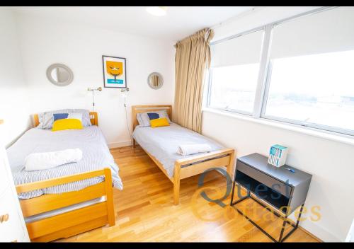 a twin bedroom with two beds and a window at The Waves - Camber Sands - East Sussex in Camber