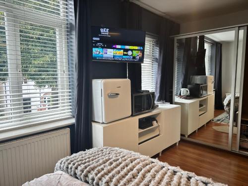 a bedroom with a television and a room with a bed at Double Bedroom inside Family Home in Nottingham