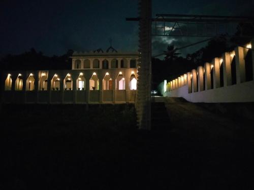 a building lit up at night with lights at JK Home stay in Sultan Bathery