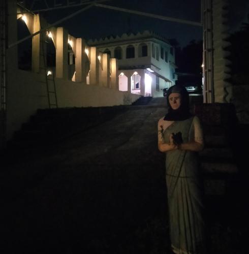 a woman standing in the dark at night at JK Home stay in Sultan Bathery