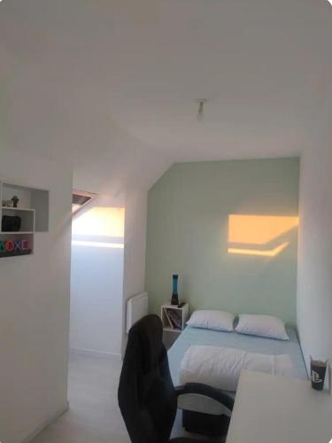 une chambre avec un lit, un bureau et une chaise dans l'établissement Maison individuelle, à Rogerville