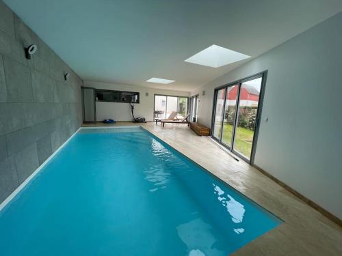 a large swimming pool with blue water in a house at La Villa Atea in Joue-les-Tours