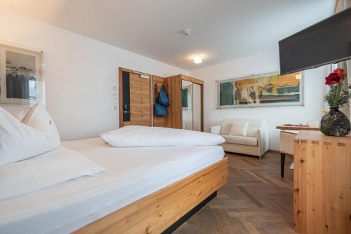 a bedroom with two beds and a couch at Hotel Liebe Sonne 4S in Sölden