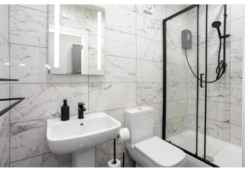 a bathroom with a toilet and a sink and a shower at Spacious Manchester Duplex 2BR Parking Sleeps 6 in Bolton