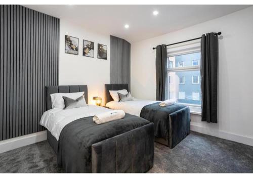a bedroom with two beds and a window at Spacious Manchester Duplex 2BR Parking Sleeps 6 in Bolton