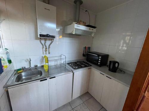 a small kitchen with a sink and a microwave at Casa en El Canelo - Algarrobo in Algarrobo