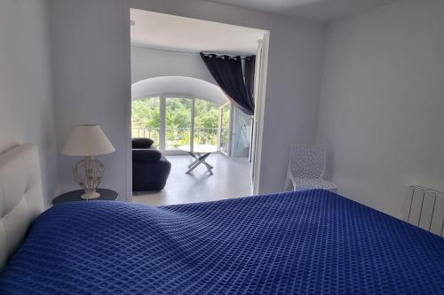 une chambre avec un lit bleu et un salon dans l'établissement Appt vue parc, avec terrasse, à Châtel-Guyon