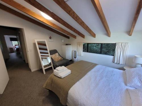 a bedroom with a large bed and a chair at Waterfront 8 bedroom home with hot tub and mooring in French Farm