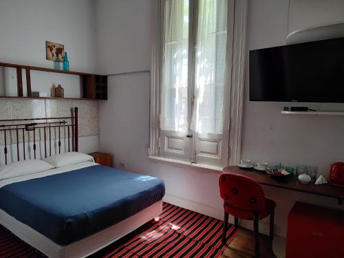 a bedroom with a bed and a desk and a television at HOTEL Boutique Casablanca Adrogué in Adrogué