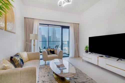 a living room with a large flat screen tv at Burj Royale - Luxury Stay with Panoramic Burj Khalifa & Fountain View in Dubai
