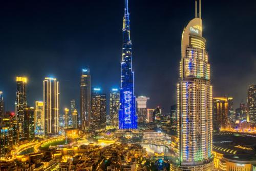 a city skyline at night with a tall building at Burj Royale - Luxury Stay with Panoramic Burj Khalifa & Fountain View in Dubai