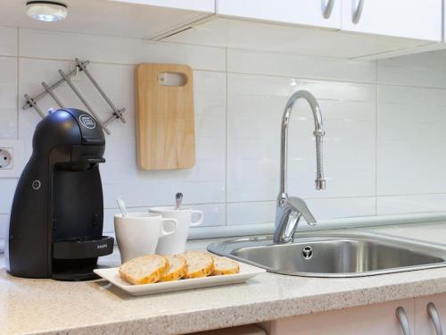 een aanrecht met een broodmixer en een bord met brood bij Parallel - Family Flat 2 rooms in Barcelona