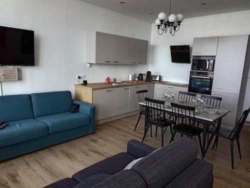 - un salon avec un canapé bleu et une table avec des chaises dans l'établissement Sable d'Opale, à Le Portel