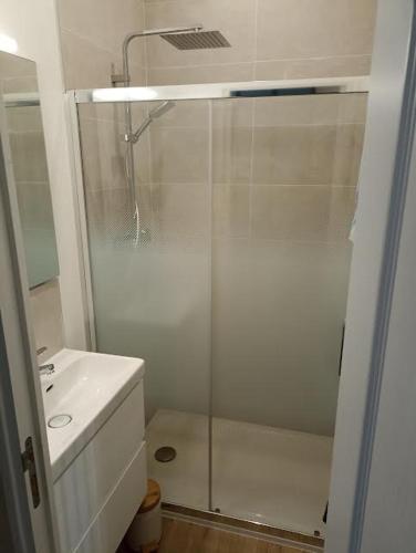 une salle de bain blanche avec une douche et un lavabo dans l'établissement Sable d'Opale, à Le Portel