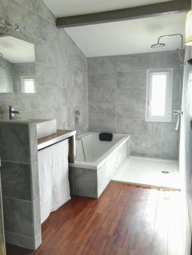 une salle de bain avec une baignoire et un lavabo dans l'établissement La VILLA GRIMAUDE, à Jacou