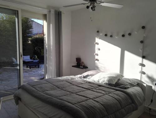 une chambre avec un lit et une grande fenêtre dans l'établissement La VILLA GRIMAUDE, à Jacou