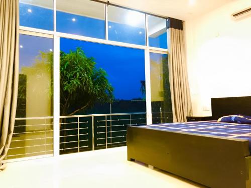 a bedroom with a bed and a large window at White House Inn in Lukasgoda