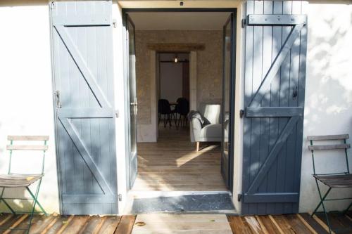 an open door leading to a room with chairs at La petite longère La mercerie in Bourges