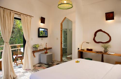 a bedroom with a bed and a mirror and a window at Stop and Go Boutique Hotel in Da Lat