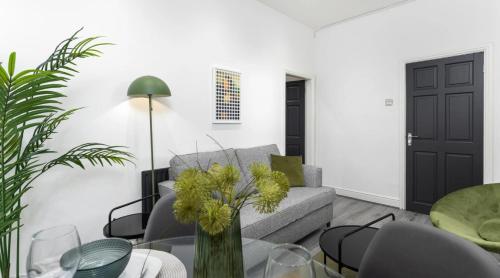 a living room with a couch and a table at Residency apartments Sefton road in Walton on the Hill