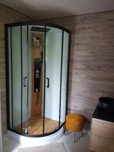 a large glass shower in a room with a stool at B&B Maison Colette Valgorge in Valgorge