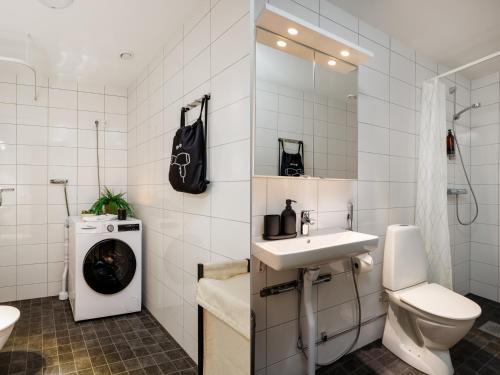 a white bathroom with a sink and a toilet at Guestly Homes - 3BR Superior Apartment in Boden
