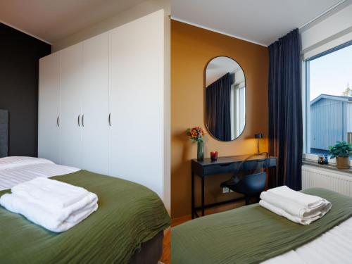 a bedroom with two beds and a desk and a mirror at Guestly Homes - 3BR Superior Apartment in Boden