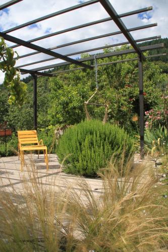a wooden bench sitting under a pergola in a garden at La Demeure des Maitres in Chirols