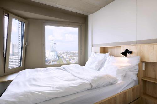 a large white bed in a room with a window at District Living in Vienna