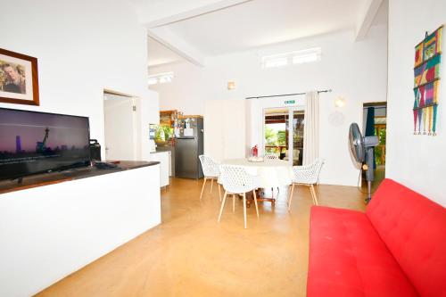 a living room with a red couch and a table at Villa de la Vallée in Rodrigues Island