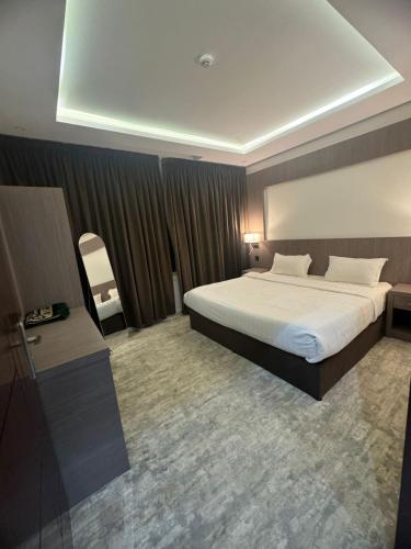 a hotel room with a large bed and a chair at درة الشرق للشقق المخدومة in Al Madinah