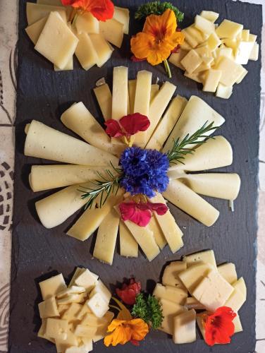 a plate of cheese and flowers on a table at Bed and Breakfast Ederhof in San Giacomo